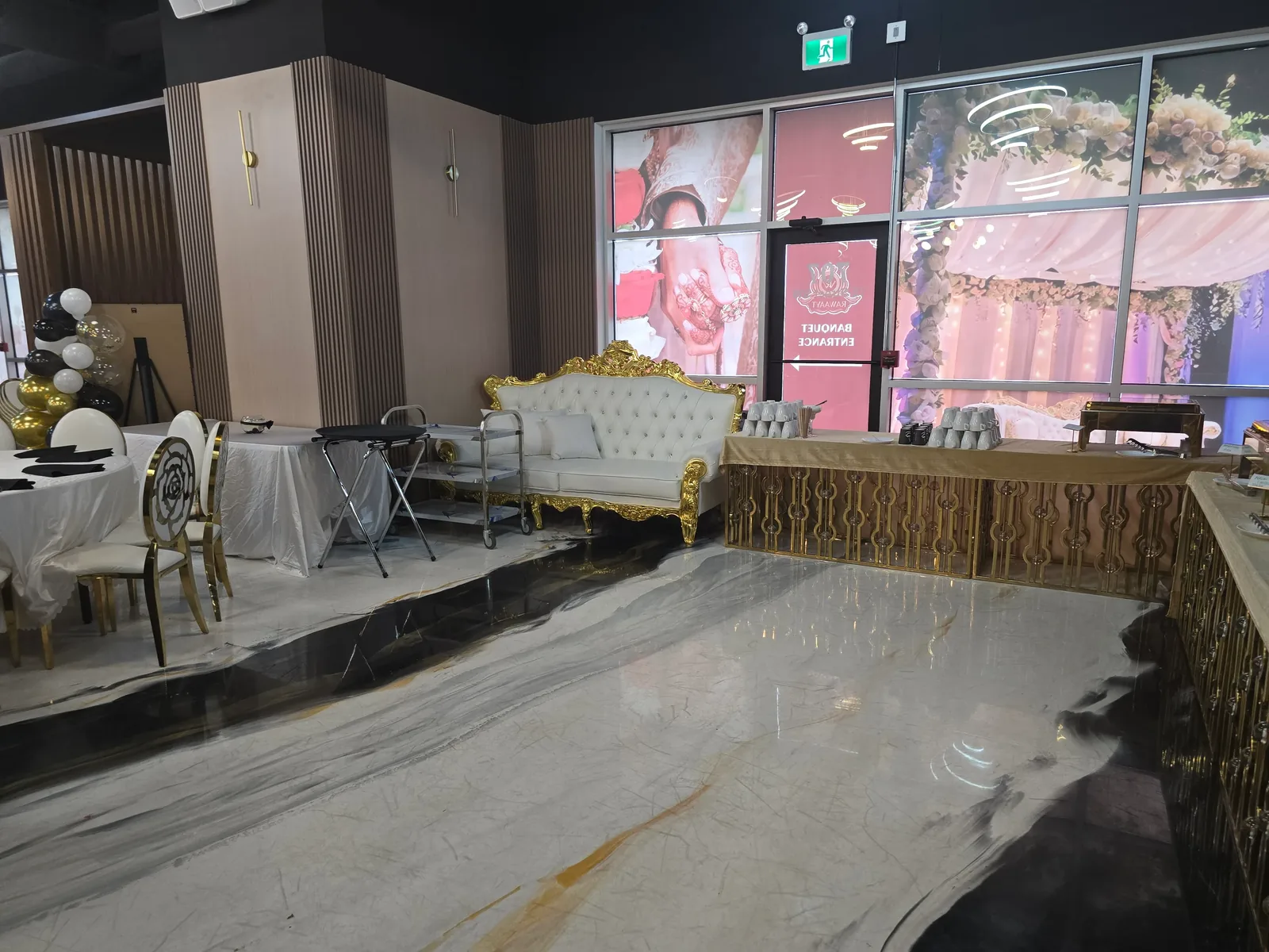 Banquet entrance and reception area at Rawaayt, south Edmonton — gold and white throne sofa, polished marble floor and buffet tables ready for guests