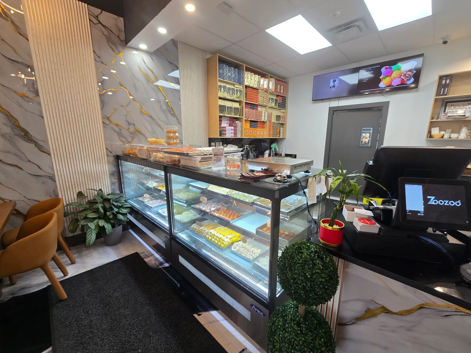 Interior of Rawaayt Sweets and Restaurant Plus Banquet showing the mithai counter, seating and Indian sweet gift boxes in Ellerslie, Edmonton